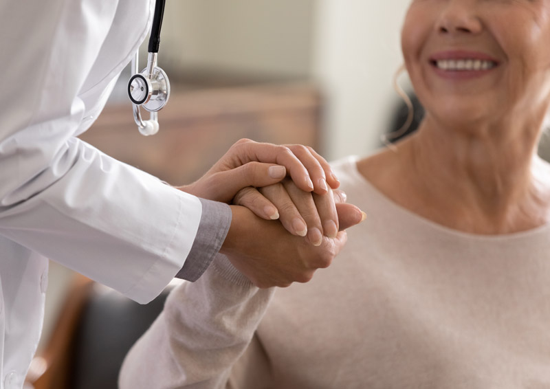 Doctor comforting patient with a reassuring hand.